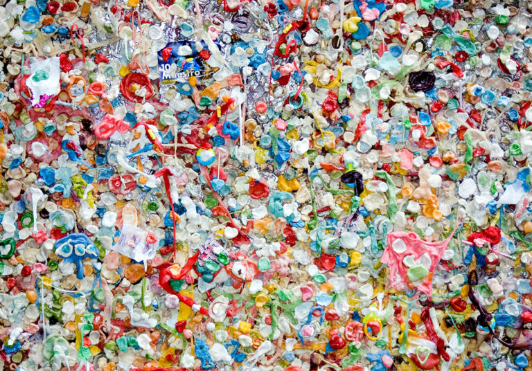 a wall full of chewed colorful bubblegum with sachets